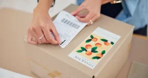 Someone putting an address label on a parcel