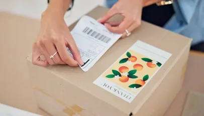 Someone putting an address label on a parcel